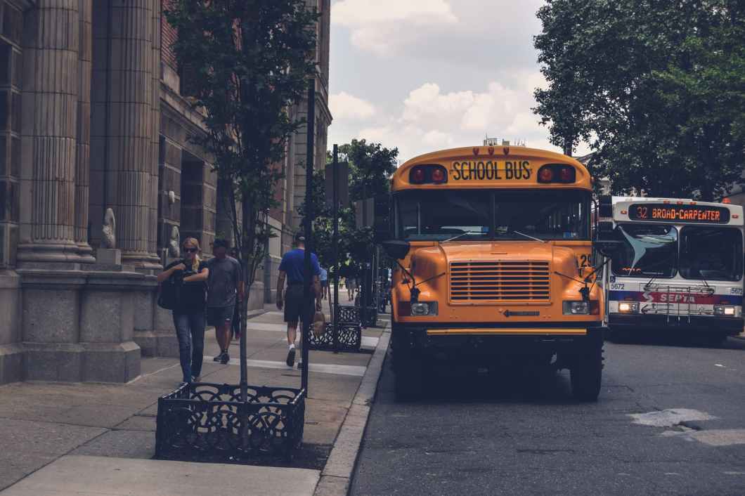 yellow school bus beside gray concrete building